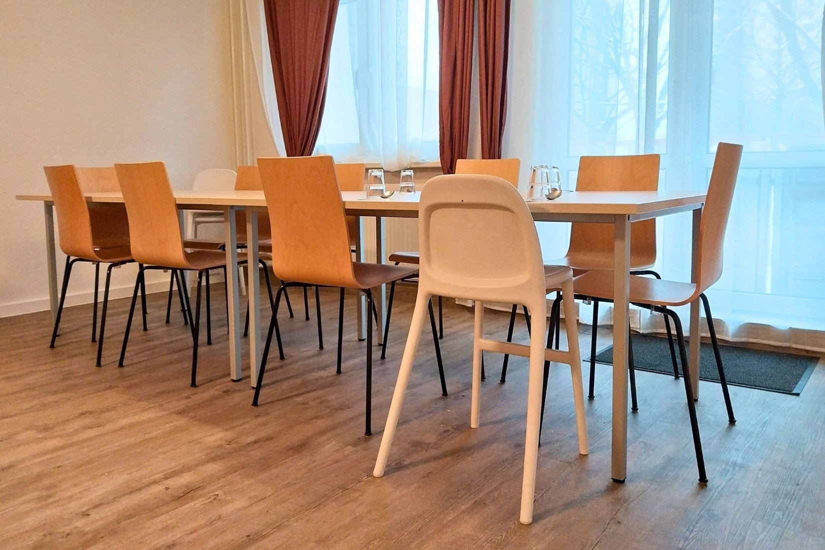 Dieses Foto zeigt den Essbereich in der Küche in der Wohngruppe Komet: Ein großer Tisch mit Stühlen für 10 Personen.