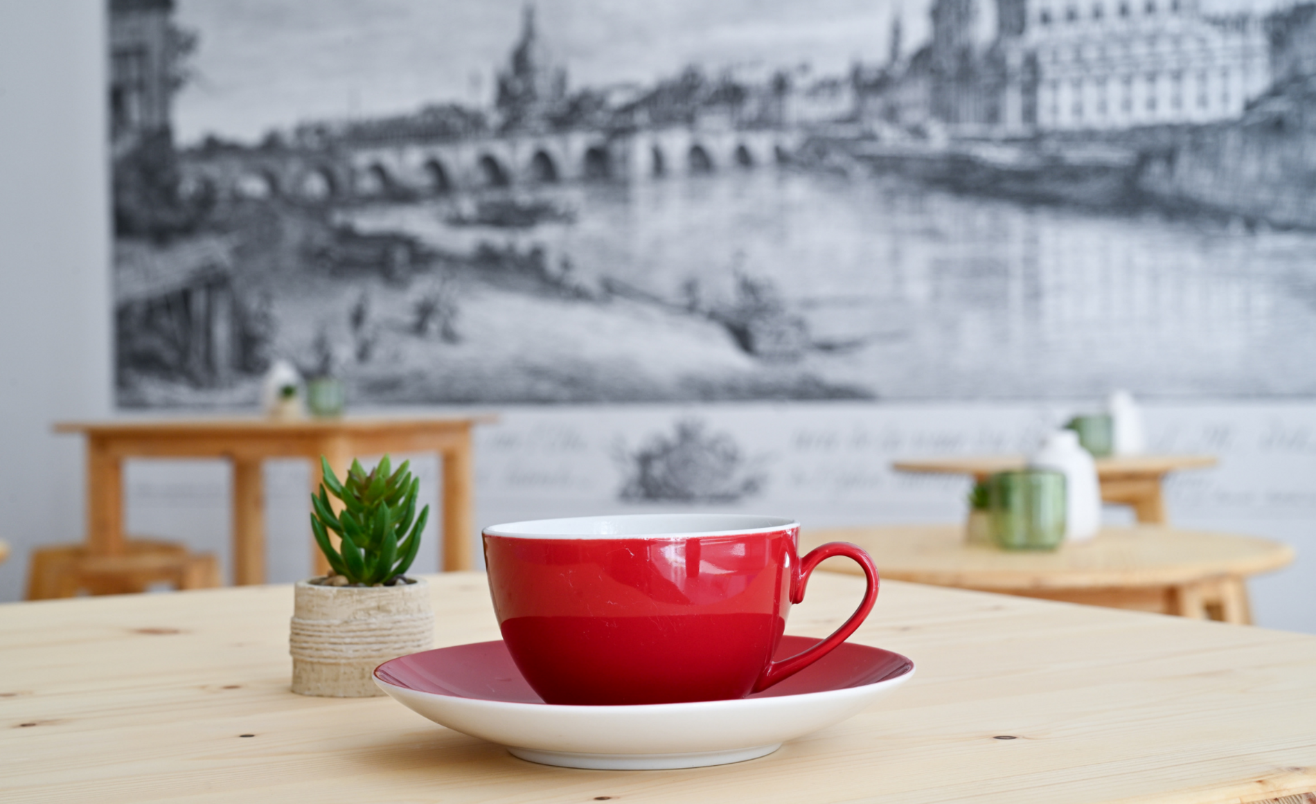 Dieses Bild zeigt eine Nahaufnahme von einer roten Kaffeetasse im Begegnungscafé im Haus der Brücke.