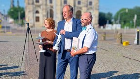 Das Bild zeigt Oberbürgermeister Hilbert,  Stadtkämmerin Jeanette Rißmann und Stadtarchiv-Chef Thomas Kübler beim symbolischen Verkauf des Goldenen Reiters.