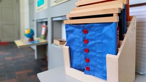 Dieses Bild zeigt ein Montessori-Lerntablett mit verschiedenen Stoffen.