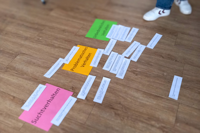 Auf dem Fußboden der Suchtberatungs- und Behandlungsstelle Dresden-Nord liegen Zettel mit verschiedenen Farben.