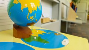 Dieses Bild zeigt ein Montessori-Spieltablett mit einer Weltkugel.