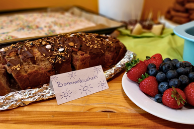Dieses Foto zeigt einen Ausschnitt des großzügigen Mitbring-Buffets. Zu sehen sind hier ein Bananenkuchen und Beeren.