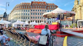Dieses Bild zeigt das Publikum des Palais Sommers von hinten mit Blick zur Bühne, auf der das Ensemble zu sehen ist.