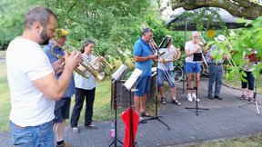 Das Bild zeigt den Posaunenchor der Kirchgemeinde beim Spielen im Garten der "Friedenshöhe"