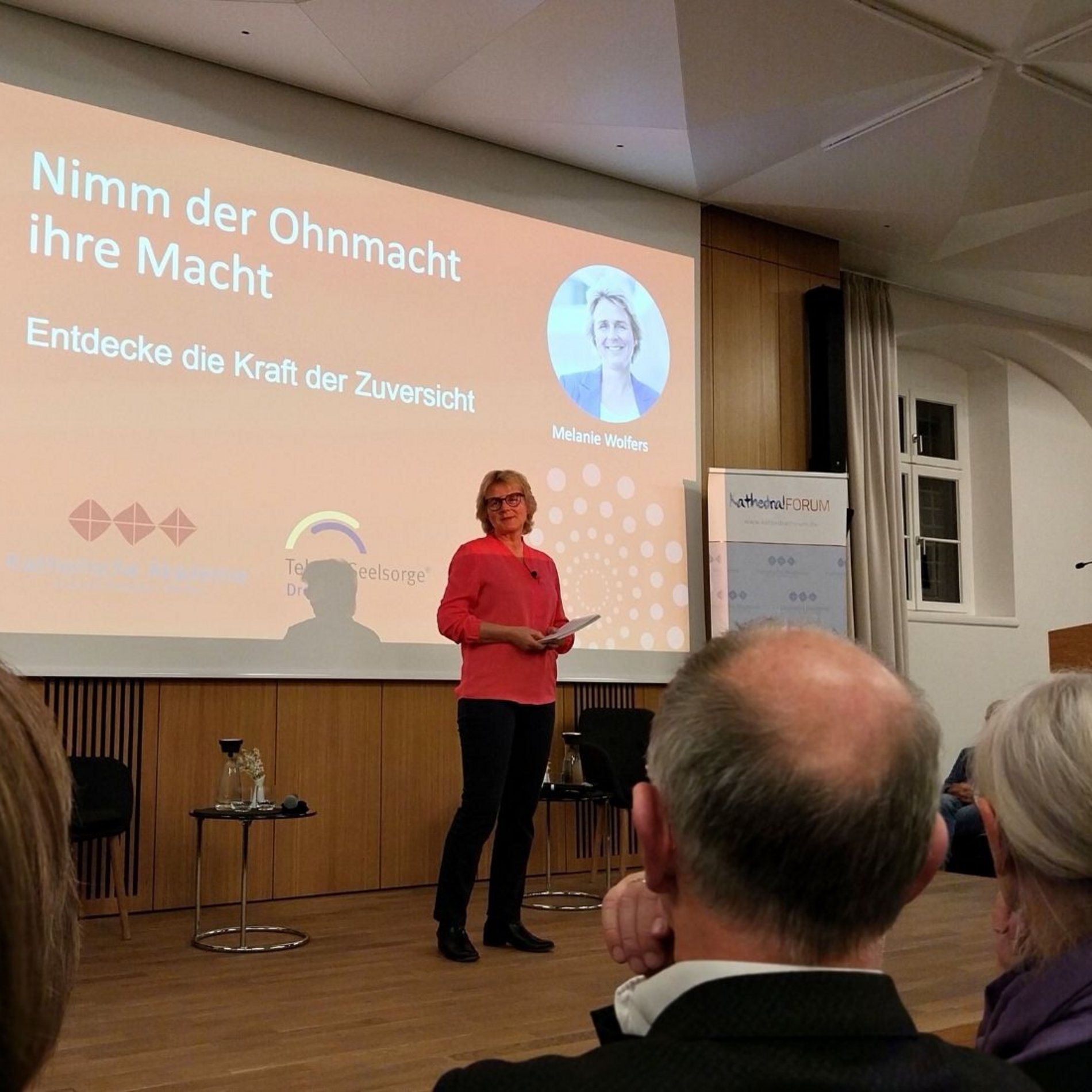 Dieses Foto zeigt die Autorin Melanie Wolfers auf der Bühne im Haus der Kathedrale beim Festvortrag.