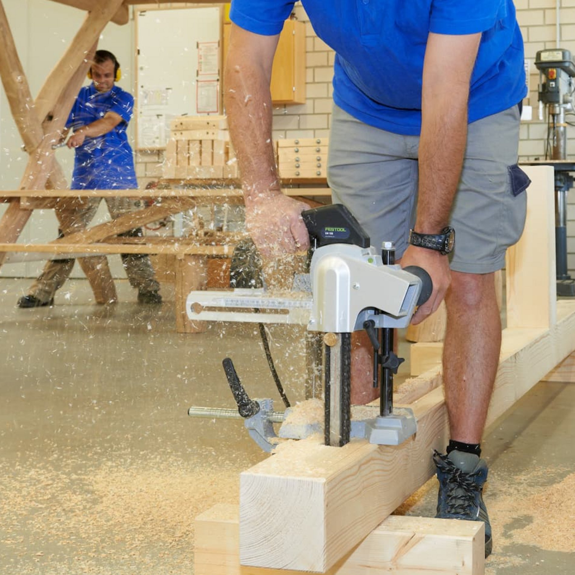 Dieses Bild zeigt zwei Beschäftigte bei der Arbeit in der Holzwerkstatt.