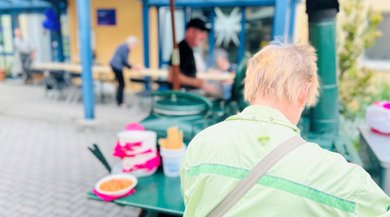 Das Bild zeigt eine Frau, die sich an einer Gulaschkanone etwas zu essen holt.