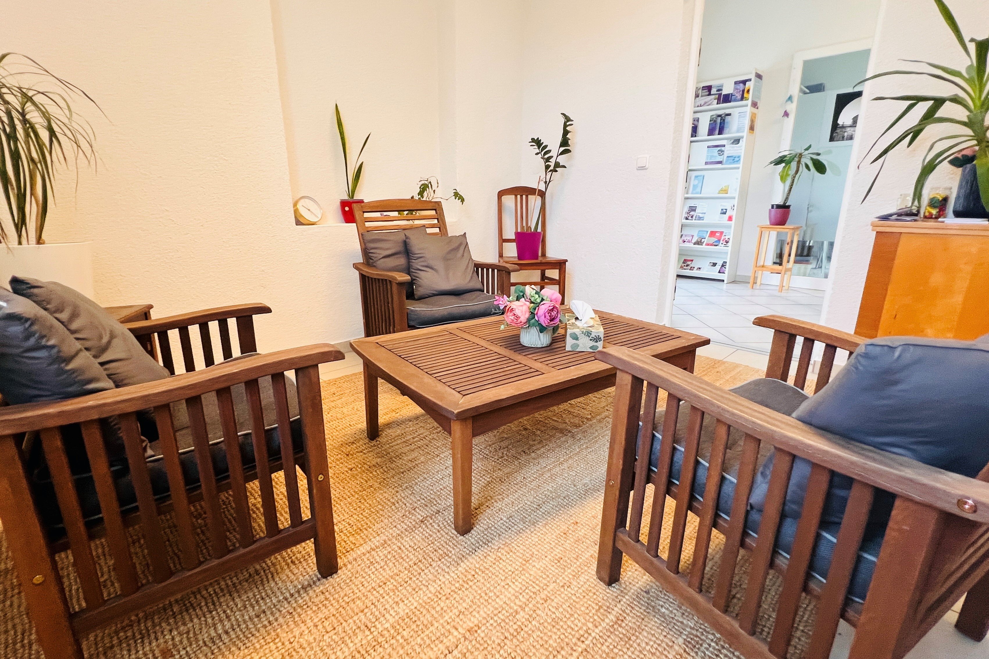 Das Bild zeigt einen hellen Raum mit einer gemütlichen Sitzgruppe aus Holz.