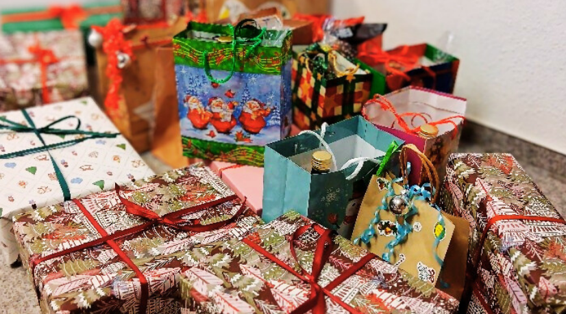 Das Bild zeigt viele weihnachtlich verpackte Geschenke.
