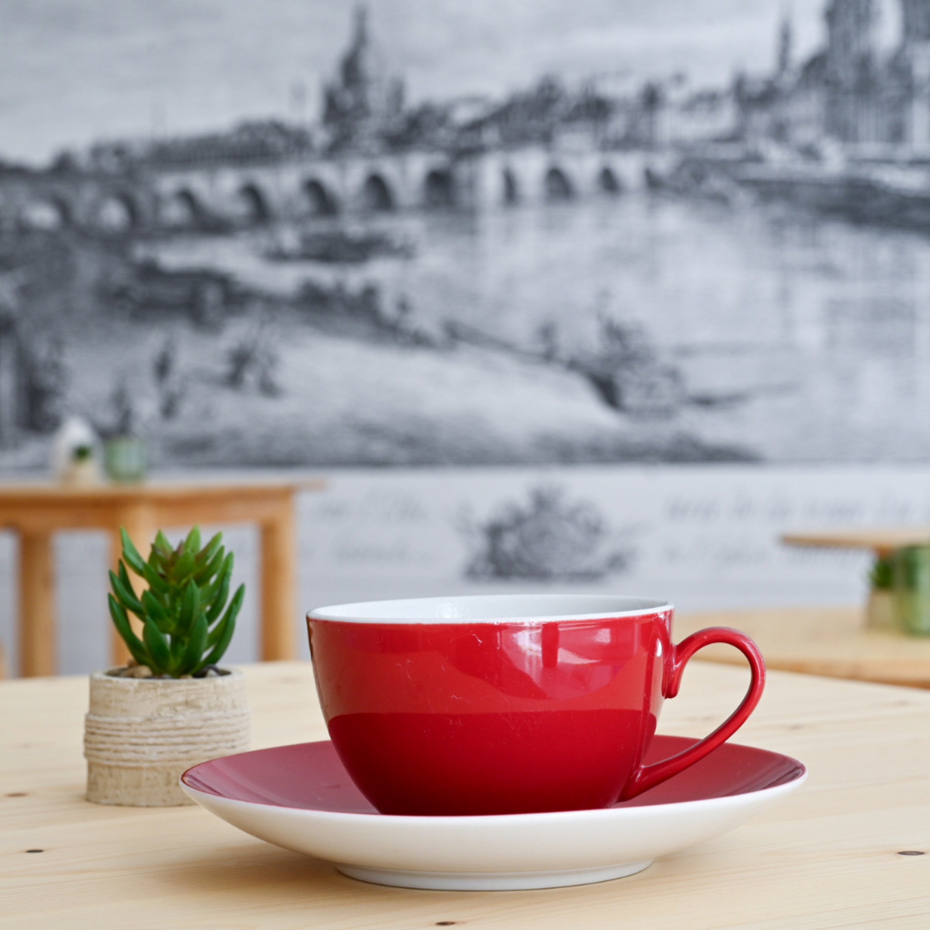 Dieses Bild zeigt eine Nahaufnahme von einer roten Kaffeetasse im Begegnungscafé im Haus der Brücke.
