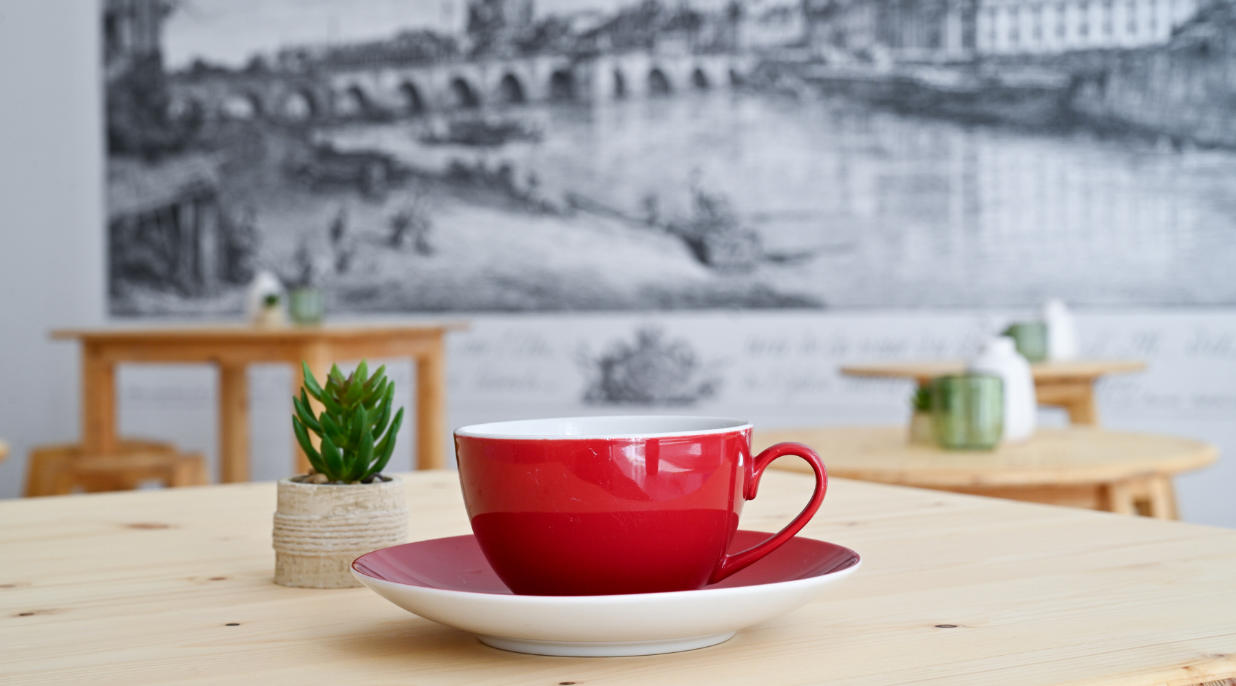 Dieses Bild zeigt eine Nahaufnahme von einer roten Kaffeetasse im Begegnungscafé im Haus der Brücke.