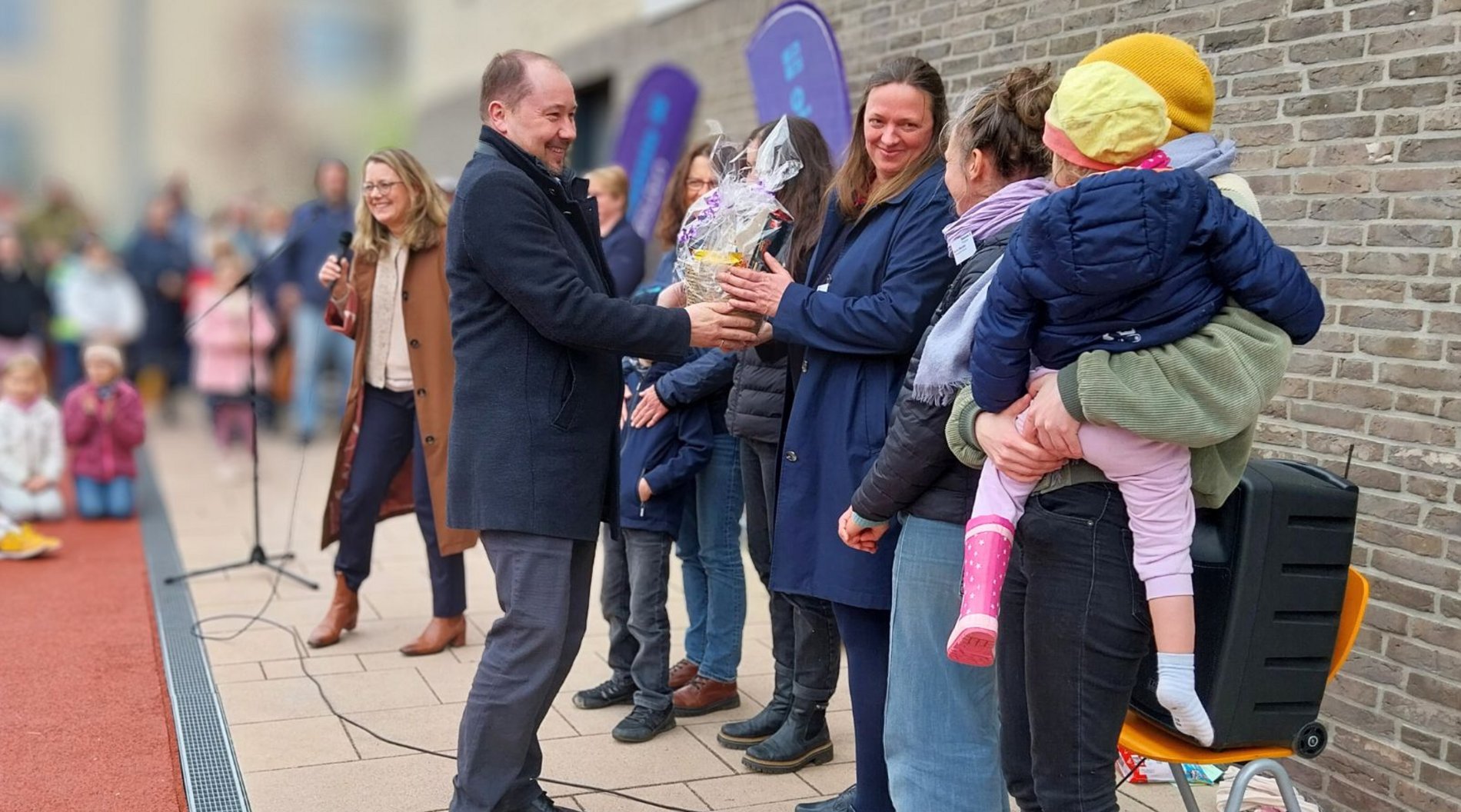 Pfarrer Thomas Slesazeck, einer der Geschäftsführer der Diakonie Dresden, gratuliert auf diesem Bild dem Team der Kita "Hasenkuhle" zum Jubiläum