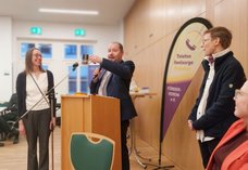 Dieses Foto zeigt Pfarrer Thomas Slesazeck, Geschäftsführer der Diakonie Dresden, sowie die beiden hauptamtlichen Mitarbeiterinnen der Telefonseelsorge Dresden bei einem Redebeitrag am Rednerpult während des Emfangs.