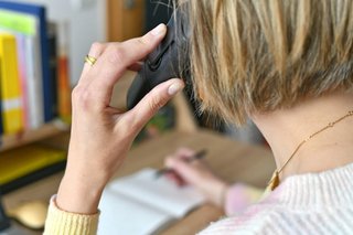 Frau mit Telefonhörer bei der Telefon-Seelsorge